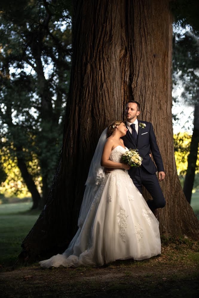 Couple de mariés qui posent devant un arbre