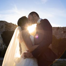 Couple de mariés qui s'embrasse au coucher du soleil
